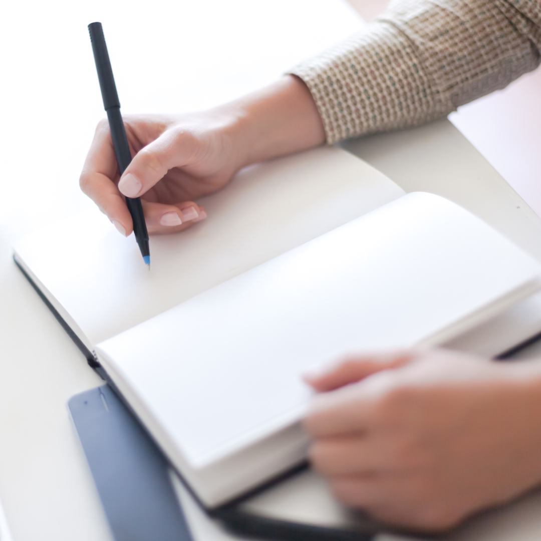 Hands with pen taking notes in notebook